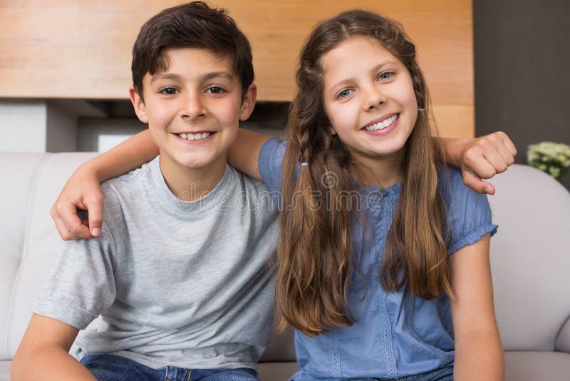 Portrait de petits enfants de mêmes parents de sourire dans le salon photo stock Portrait de petits enfants de mêmes parents de sourire dans le salon photo stock
