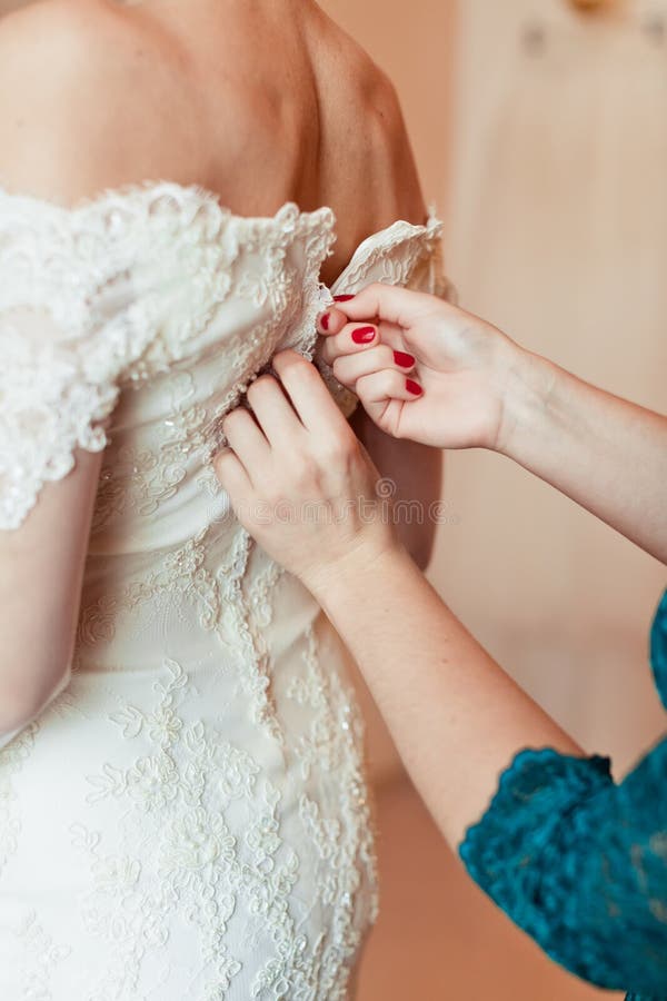 Portrait de plan rapproché d'une domestique d'honneur aidant la jeune mariée image stock Portrait de plan rapproché d'une domestique d'honneur aidant la jeune mariée image stock