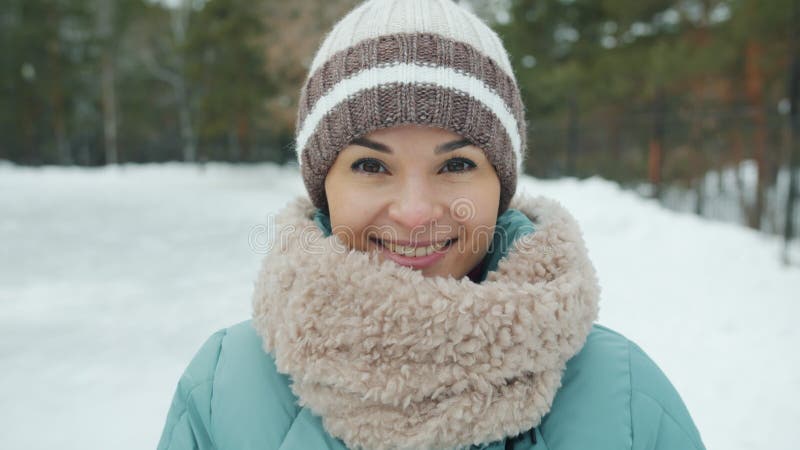 Portrait de ralenti de jeune femme séduisante dans des vêtements d'hiver tenant des ourdoors dans le parc en hiver banque de vidéos