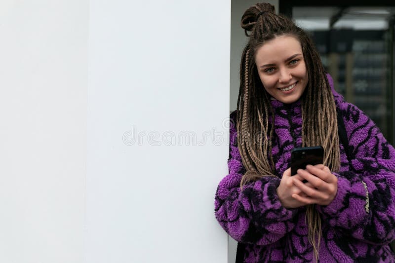 Portrait de rue d'une jeune femme percée et cadenas africains debout contre un mur image stock