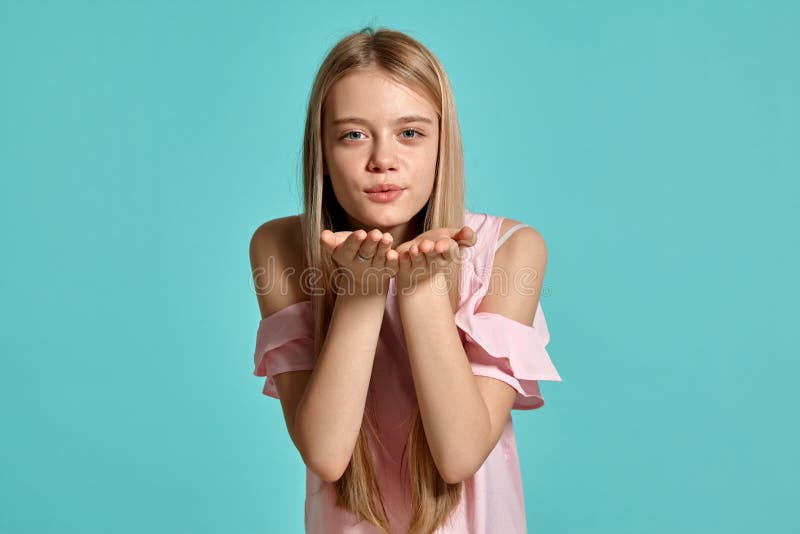 Portrait de studio d'une adolescente blonde de belle fille dans un T-shirt rose posant au-dessus d'un fond bleu image stock Portrait de studio d'une adolescente blonde de belle fille dans un T-shirt rose posant au-dessus d'un fond bleu image stock