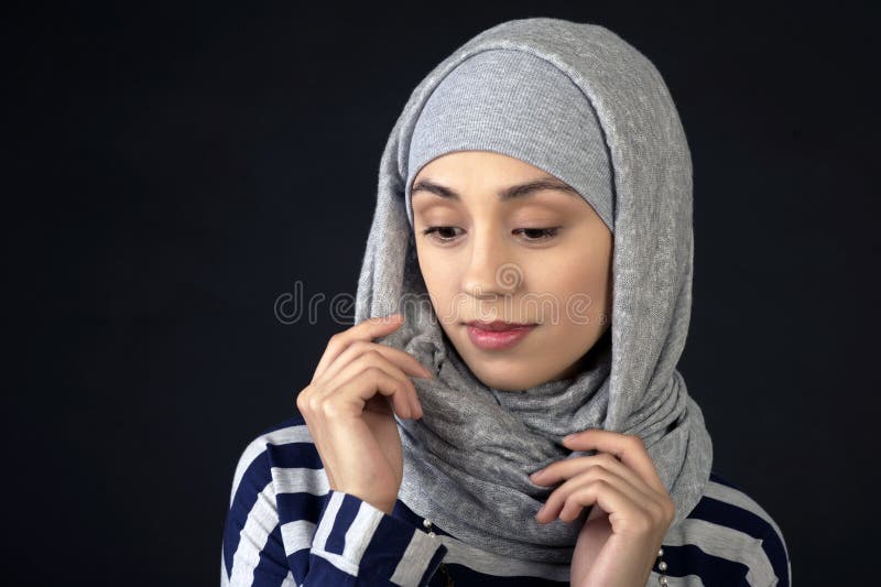 Portrait de studio d'une belle jeune femme de type du Moyen-Orient, dans une écharpe peu commune sur sa tête, sur un fond foncé images stock Portrait de studio d'une belle jeune femme de type du Moyen-Orient, dans une écharpe peu commune sur sa tête, sur un fond foncé images stock