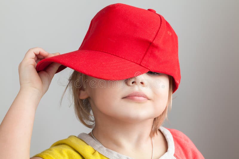 Portrait de studio de bébé drôle dans la casquette de baseball rouge photos libres de droits Portrait de studio de bébé drôle dans la casquette de baseball rouge photos libres de droits
