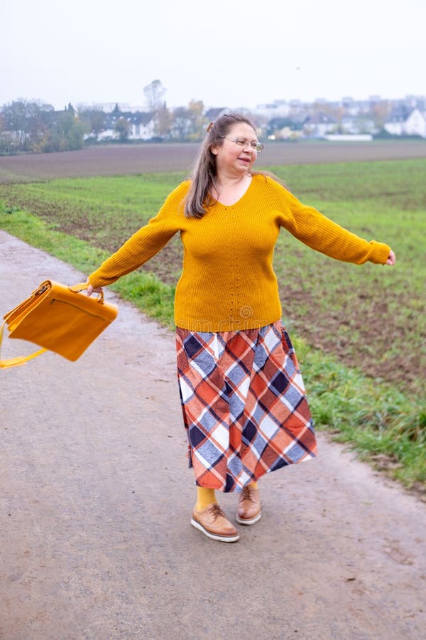 Portrait de style de vie naturel femme joyeuse en lunettes jouissant de la marche extérieure assorti aux accessoires jaunes photo stock
