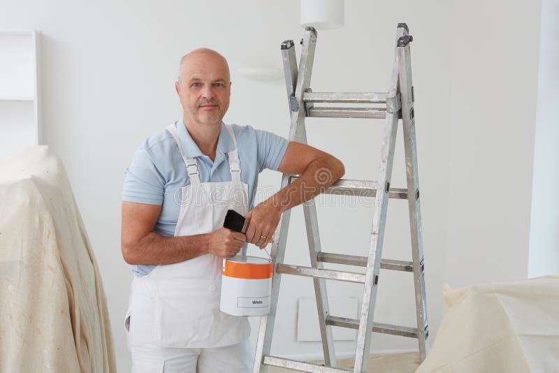 Decorator Painting Flower on White Wall in Room. Interior Stock Photo