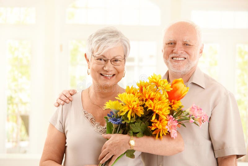 Portrait der glücklichen älteren Paare mit Blumen stockbilder Portrait der glücklichen älteren Paare mit Blumen stockbilder