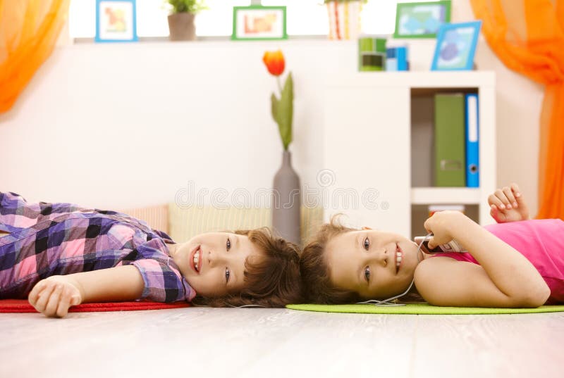 Portrait of young girls enjoying music via earphones, smiling at camera. Portrait of young girls enjoying music via earphones, smiling at camera.