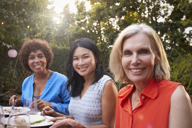 Portrait des amis féminins mûrs appréciant le repas extérieur image libre de droits Portrait des amis féminins mûrs appréciant le repas extérieur image libre de droits