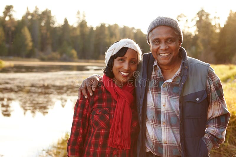 Portrait des couples supérieurs d'Afro-américain marchant par le lac photo stock Portrait des couples supérieurs d'Afro-américain marchant par le lac photo stock
