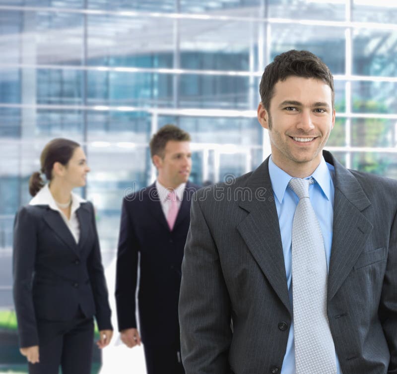 Portrait of happy businessman standing in office lounge smiling. Portrait of happy businessman standing in office lounge smiling.