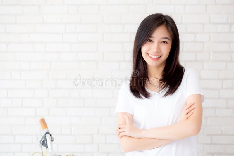 Portrait du beau jeune bonheur asiatique de femme se tenant sur le fond grunge de brique de mur de texture grise de ciment photo stock Portrait du beau jeune bonheur asiatique de femme se tenant sur le fond grunge de brique de mur de texture grise de ciment photo stock