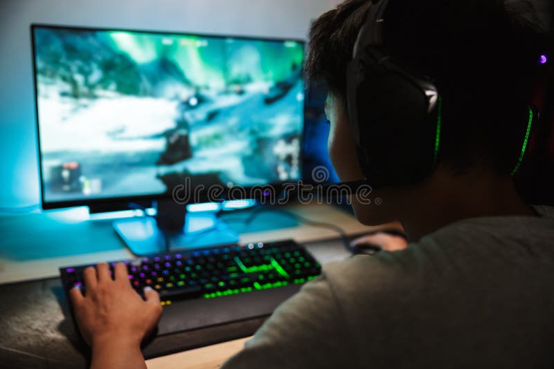 Portrait du garçon adolescent asiatique de gamer jouant les jeux vidéo o en ligne photographie stock libre de droits Portrait du garçon adolescent asiatique de gamer jouant les jeux vidéo o en ligne photographie stock libre de droits