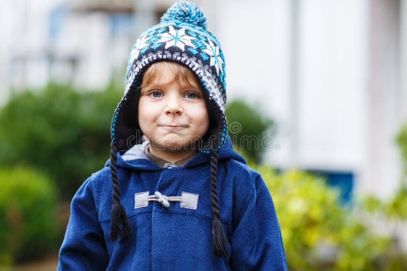 Portrait du garçon mignon d'enfant en bas âge souriant le jour froid d'hiver. photo libre de droits Portrait du garçon mignon d'enfant en bas âge souriant le jour froid d'hiver. photo libre de droits