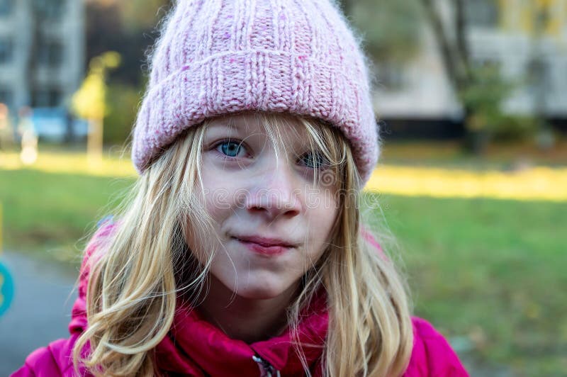 portrait of an eight-year-old girl with disheveled hair on the street on an autumn day stock photography