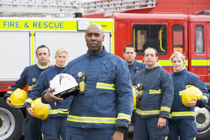 Portrait of a group of firefighters by fire engine. Portrait of a group of firefighters by fire engine