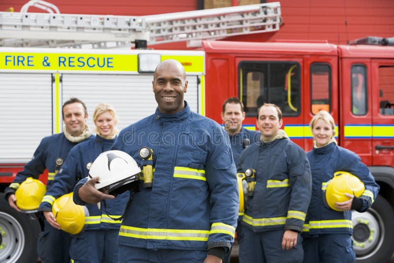 Portrait of a group of firefighters by a fire engine. Portrait of a group of firefighters by a fire engine