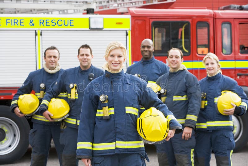 Portrait of a group of firefighters by a fire engine. Portrait of a group of firefighters by a fire engine