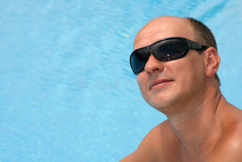 Portrait eines jungen Mannes nahe dem Swimmingpool lizenzfreies stockfoto Portrait eines jungen Mannes nahe dem Swimmingpool lizenzfreies stockfoto
