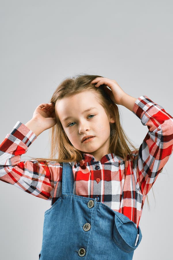 Portrait eines modernen Mädchens im Overalls eines karierten Hemds und des Denims. Studiomodeschießen stockbilder