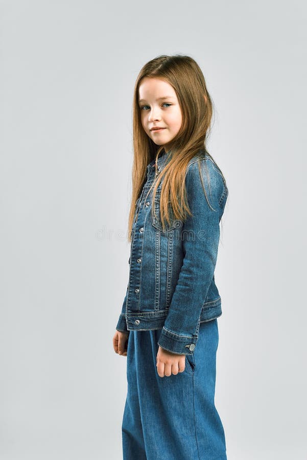 Portrait eines recht kleinen Mädchens.. Kind in einer Denimklage. Studiophotographie stockbild