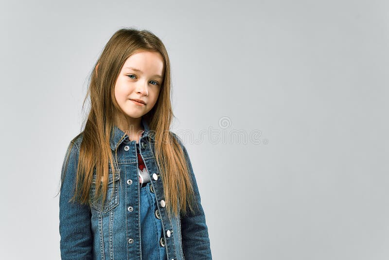 Portrait eines recht kleinen Mädchens.. Kind in einer Denimklage. Studiophotographie stockfotografie