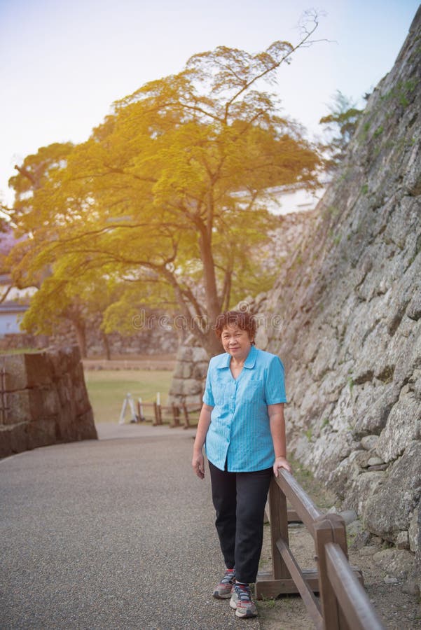 Portrait of elder asian woman in blue shirt standing in japan ga stock photos Portrait of elder asian woman in blue shirt standing in japan ga stock photos