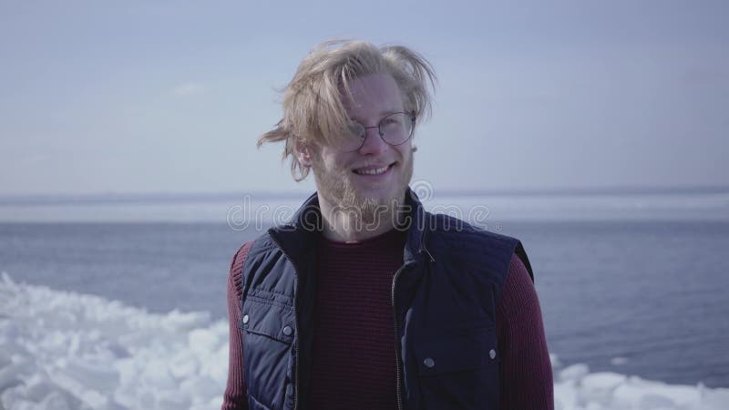 Portrait en gros plan de jeune homme blond attirant en verres regardant loin touchants ses cheveux Type attirant de clips vidéos Portrait en gros plan de jeune homme blond attirant en verres regardant loin touchants ses cheveux Type attirant de clips vidéos