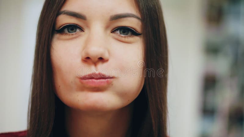 Portrait en gros plan de la belle fille heureuse mangeant un beignet, appréciant un casse-croûte au travail banque de vidéos