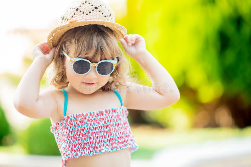 Portrait en gros plan de la petite fille adorable à la station de vacances tropicale, palmiers au fond, jour d'été ensoleillé photographie stock libre de droits Portrait en gros plan de la petite fille adorable à la station de vacances tropicale, palmiers au fond, jour d'été ensoleillé photographie stock libre de droits