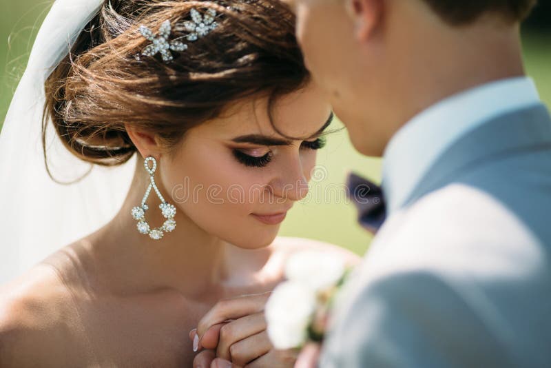 Portrait en gros plan des nouveaux mariés le jour du mariage La jeune mariée étreint avec le marié avant le baiser Homme dans le photo libre de droits Portrait en gros plan des nouveaux mariés le jour du mariage La jeune mariée étreint avec le marié avant le baiser Homme dans le photo libre de droits