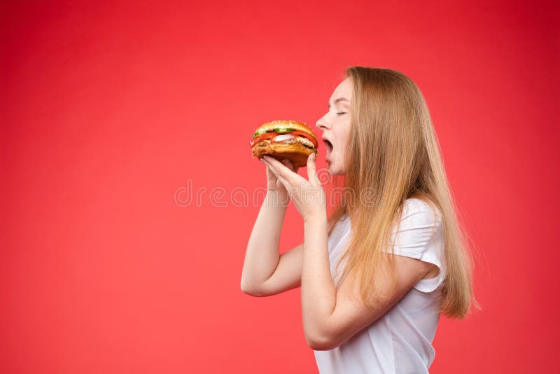 Portrait en gros plan moyen de la belle jeune femme de mode mordant le sandwich appétissant frais images libres de droits Portrait en gros plan moyen de la belle jeune femme de mode mordant le sandwich appétissant frais images libres de droits