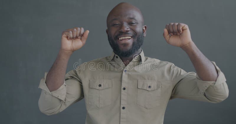Portrait en mouvement lent d'un Africain-Américain heureux qui danse en souriant en regardant la caméra clips vidéos
