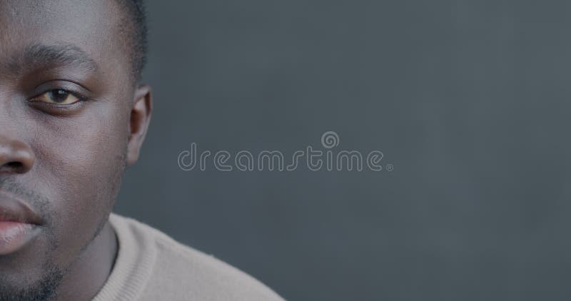Portrait en mouvement lent d'un Afro-Américain moitié visage regardant caméra avec une expression sérieuse banque de vidéos