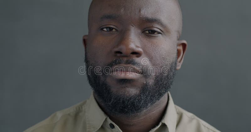 Portrait en mouvement lent d'un jeune Africain Américain regardant la caméra avec une expression sérieuse et confiante banque de vidéos