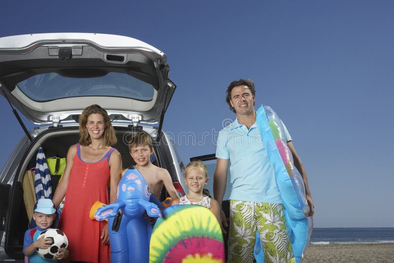 Portrait Of Family With By Car At Beach