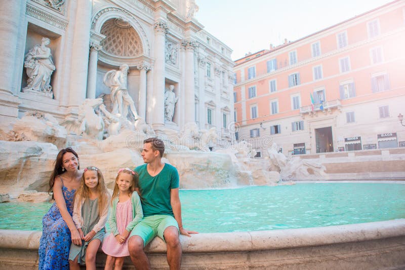 Portrait of family at Fontana di Trevi, Rome, Italy. Happy parents and kids enjoy italian vacation holiday in Europe.