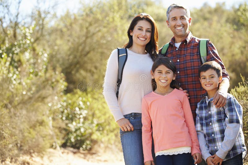 Portrait Of Family Hiking In Countryside Wearing Backpacks