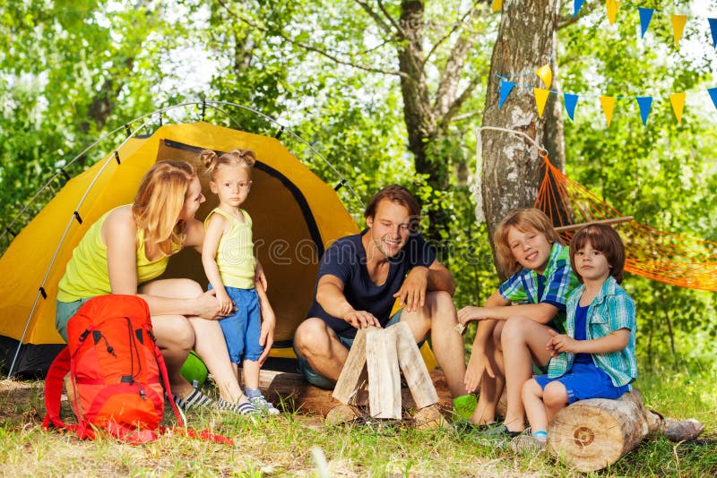 Portrait of family making camp fire in the woods