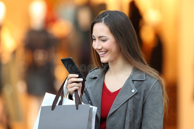 Fashion shopper using a smart phone in a mall royalty free stock photo Fashion shopper using a smart phone in a mall royalty free stock photo