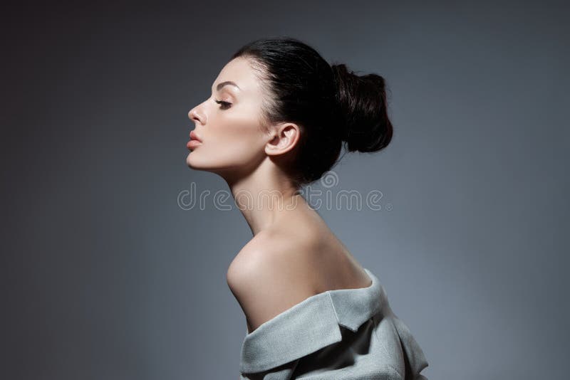 Portrait of a fashion woman with a bunch of hair. Perfect face profile girl, natural cosmetics for face care royalty free stock photography Portrait of a fashion woman with a bunch of hair. Perfect face profile girl, natural cosmetics for face care royalty free stock photography