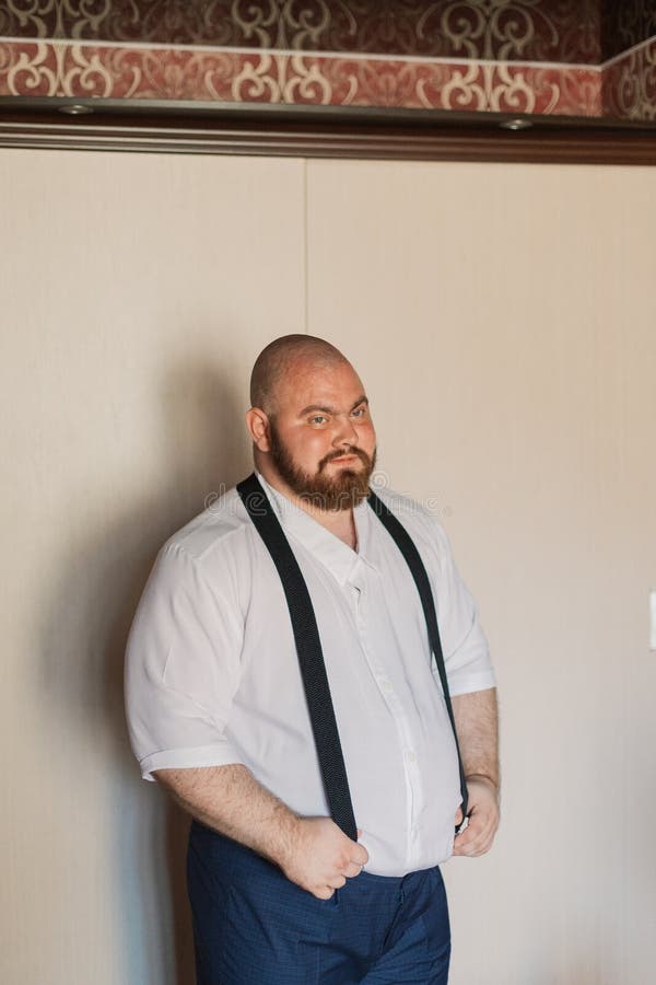 Portrait of a Fat Man with Suspenders on His Pants. Stock Photo Image