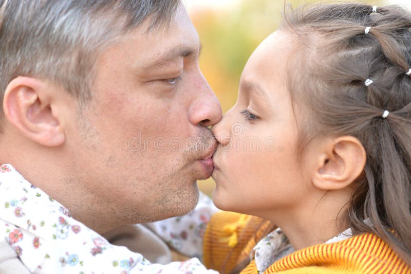 Portrait of father and daughter in park.