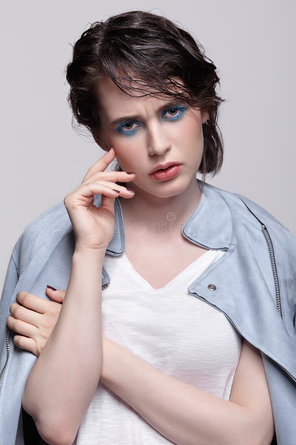 Portrait of female in blue jacket. Woman with unusual beauty makeup and wet hair, and blue shadows make-up royalty free stock photography Portrait of female in blue jacket. Woman with unusual beauty makeup and wet hair, and blue shadows make-up royalty free stock photography