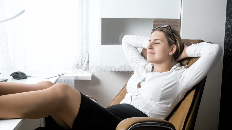 Portrait of beutiful female boss relaxing in big leather chair