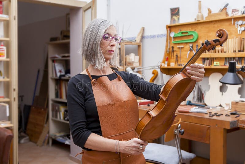 Portrait of female mature violin maker