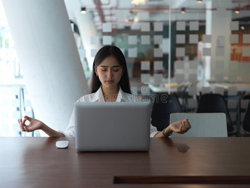 Portrait of female office worker meditating in meeting room. Portrait of female office worker meditating before start her presentation in meeting room stock photography Portrait of female office worker meditating in meeting room. Portrait of female office worker meditating before start her presentation in meeting room stock photography