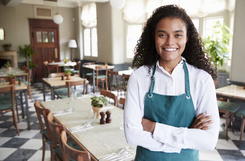 Portrait of Female Restaurant Manager in Empty Dining Room Stock Photo