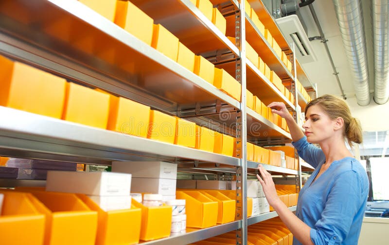 Portrait of a female worker organizing boxes on shelves
