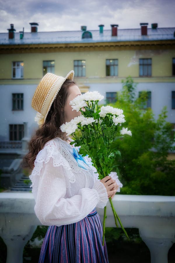 Portrait femme avec un bouquet de chrysanthèmes blancs dans des vêtements vintage image stock