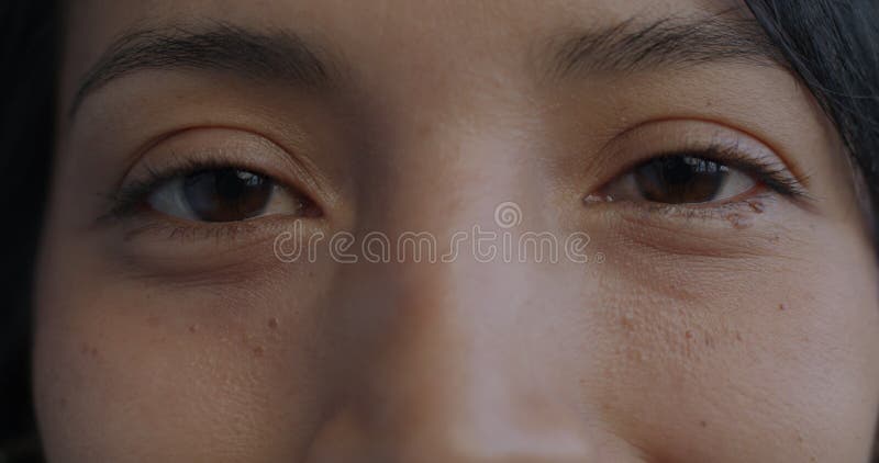 Portrait fermé des yeux féminins clignotant tandis que la femme hispanique regarde la caméra banque de vidéos